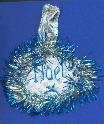 Noël brodé entouré d'une guirlande